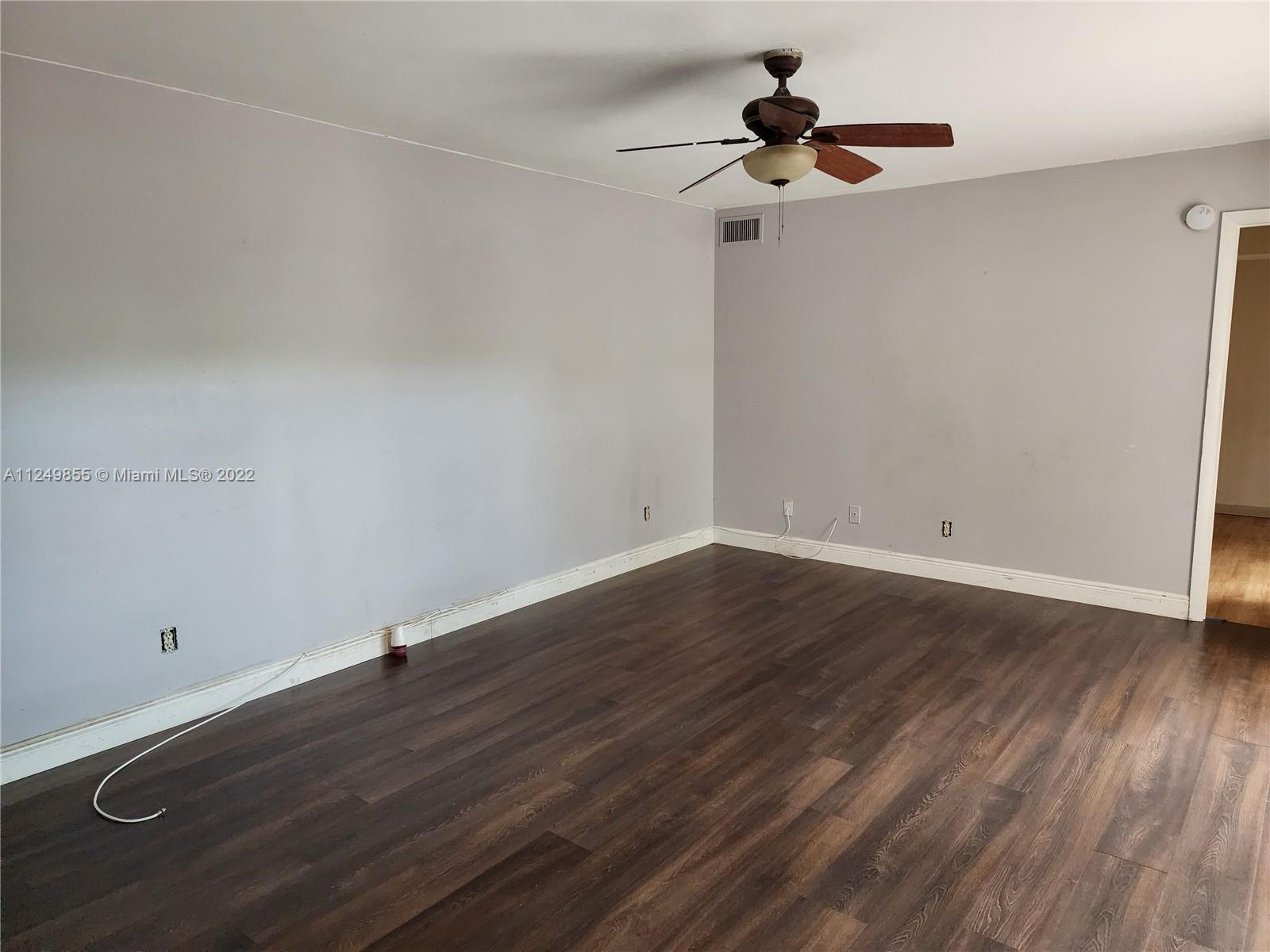 8139 Boca Rio Drive, Unit 8139 Boca Raton, FL 33433 - Photo 6 of 23 a view of room with hardwood floor and ceiling fan