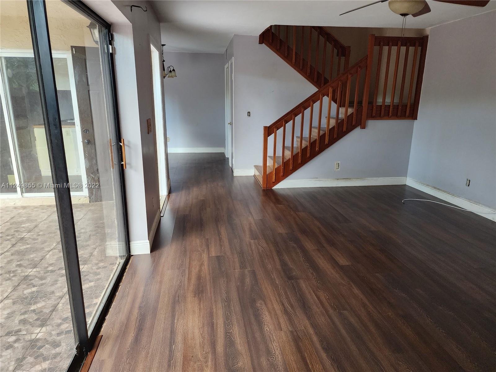 8139 Boca Rio Drive, Unit 8139 Boca Raton, FL 33433 - Photo 8 of 23 a view of a hallway with wooden floor and staircase
