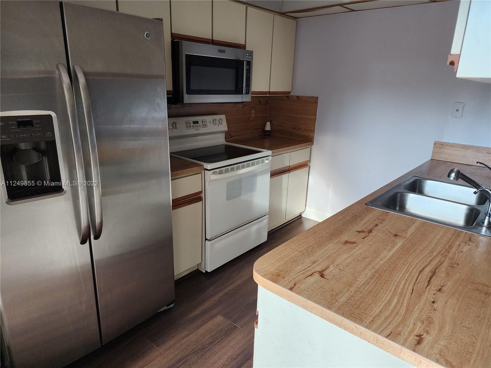 8139 Boca Rio Drive, Unit 8139 Boca Raton, FL 33433 - Photo 10 of 23 a kitchen with a refrigerator stove and microwave