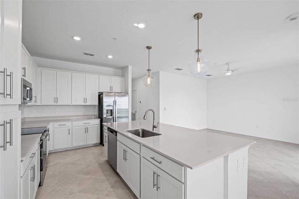 19140 Scallop Loop, Unit 401 Bradenton, FL 34211 - Photo 24 of 52 a kitchen with kitchen island granite countertop a sink a counter space appliances and cabinets
