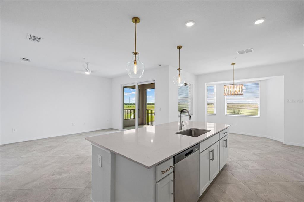 19140 Scallop Loop, Unit 401 Bradenton, FL 34211 - Photo 28 of 52 a kitchen with stainless steel appliances granite countertop a sink a center island and a window