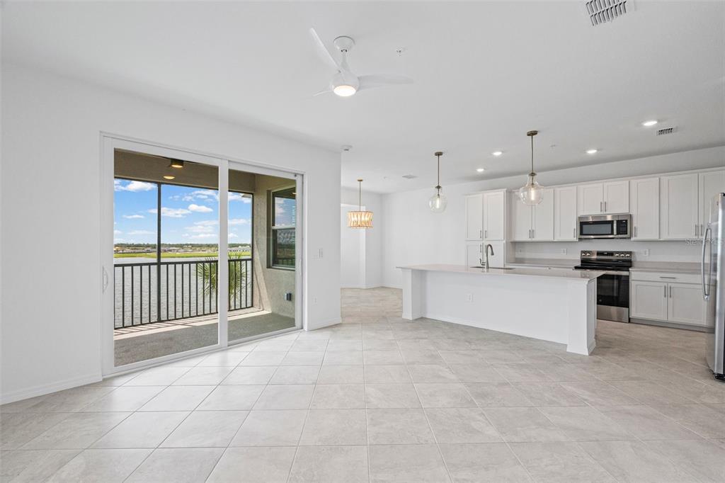 19140 Scallop Loop, Unit 401 Bradenton, FL 34211 - Photo 34 of 52 a large white kitchen with kitchen island a large window and a refrigerator a sink