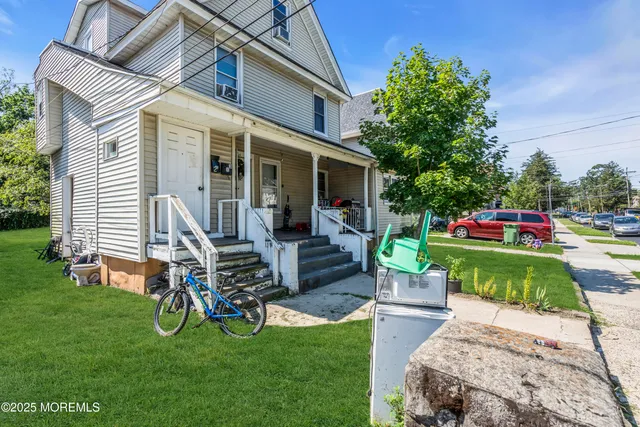 a front view of a house with garden and sitting area