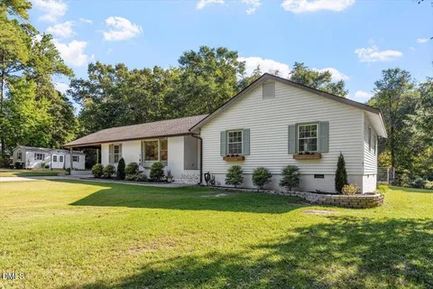 a view of a house with a yard patio and swimming pool