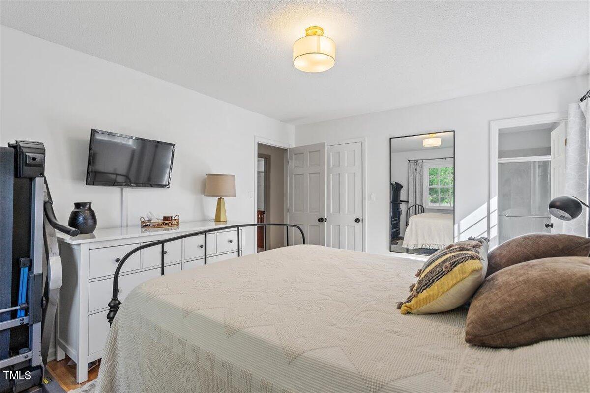 4912 Elizabeth Drive Raleigh, NC 27604 - Photo 17 of 35 a bedroom with a bed and a flat tv screen on dresser