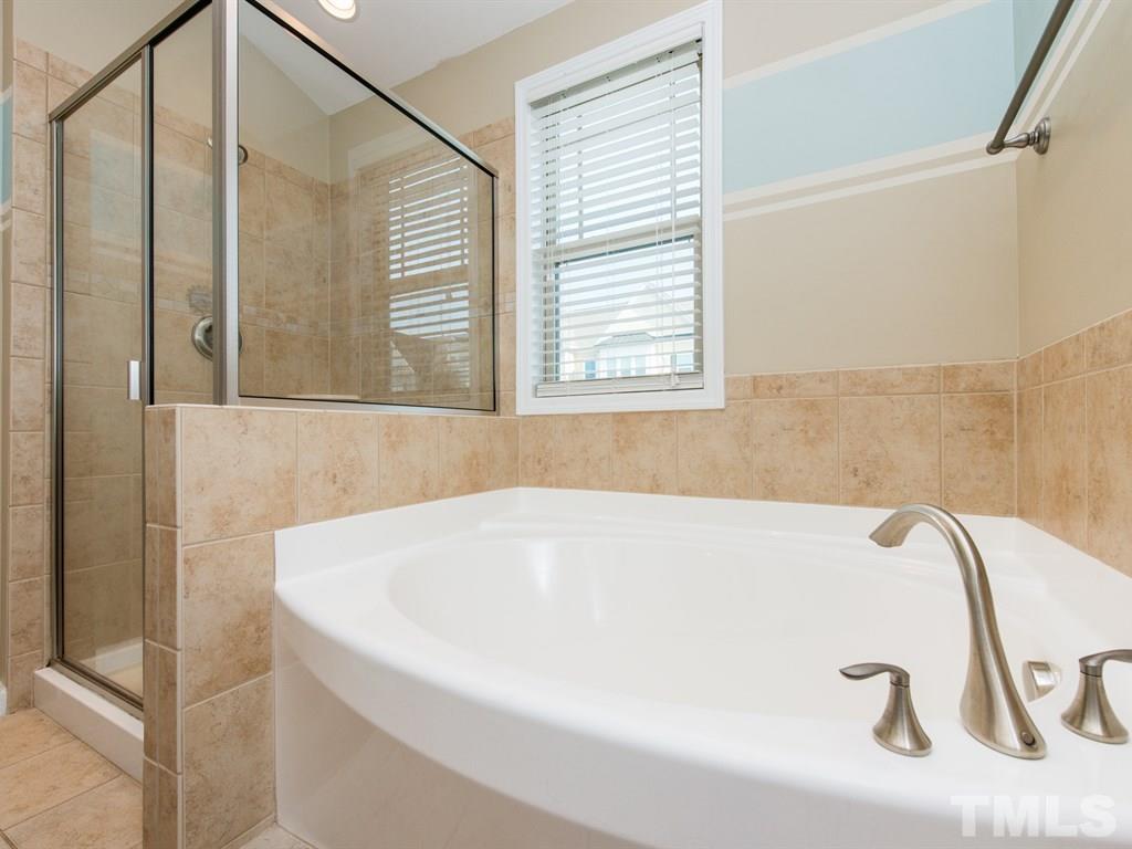 1310 Rodessa Run Raleigh, NC 27607 - Photo 16 of 25 a white bath tub sitting in a bathroom next to a window