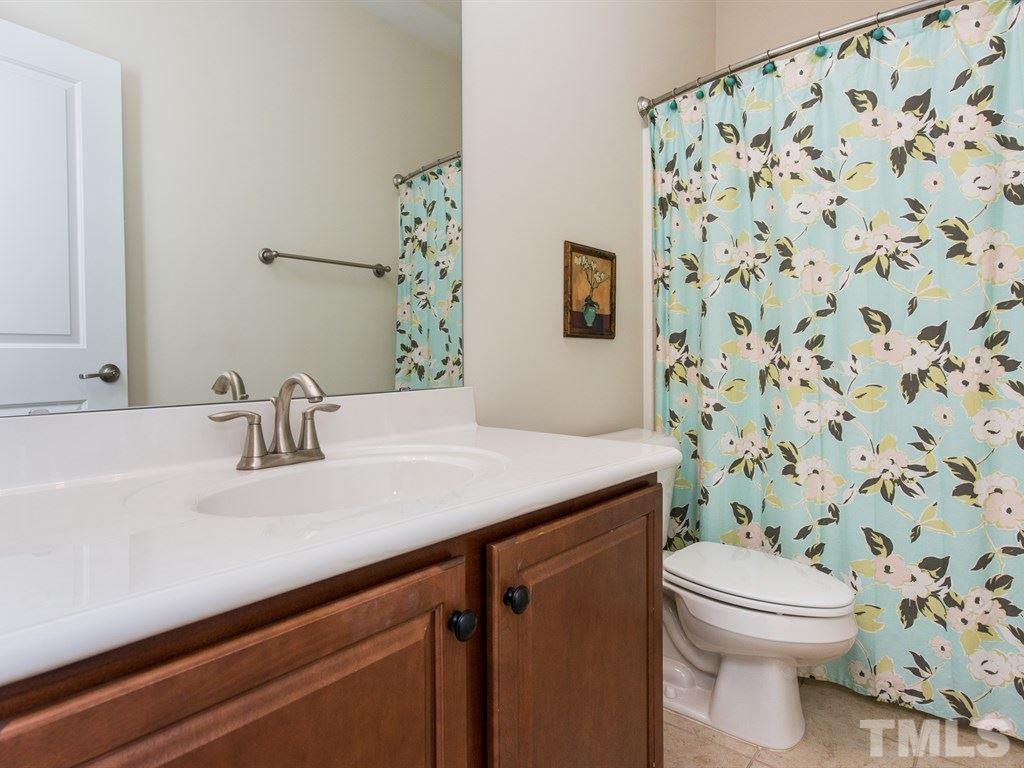 1310 Rodessa Run Raleigh, NC 27607 - Photo 18 of 25 a bathroom with a granite countertop sink a toilet and a mirror