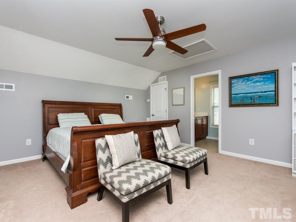 1310 Rodessa Run Raleigh, NC 27607 - Photo 20 of 25 a bedroom with a bed and a chandelier