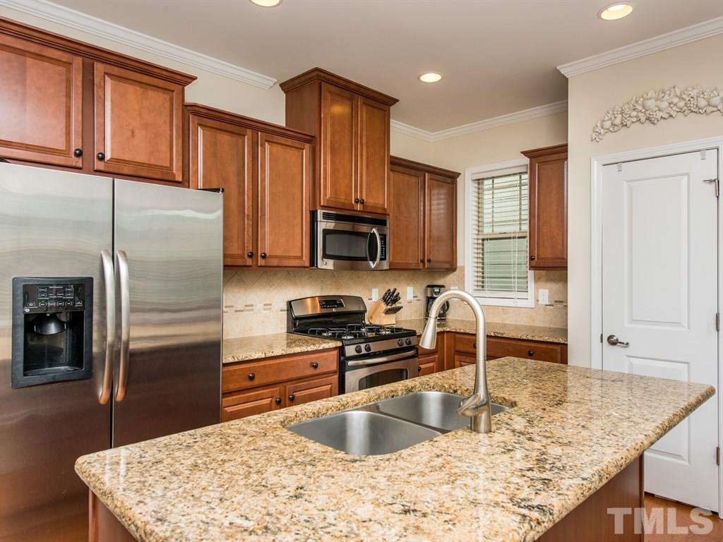1310 Rodessa Run Raleigh, NC 27607 - Photo 3 of 25 a kitchen with stainless steel appliances granite countertop a sink refrigerator and microwave