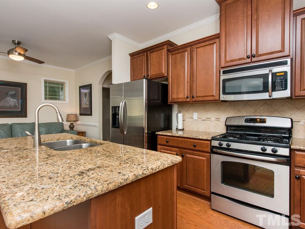 1310 Rodessa Run Raleigh, NC 27607 - Photo 4 of 25 a kitchen with kitchen island a sink and wooden cabinets