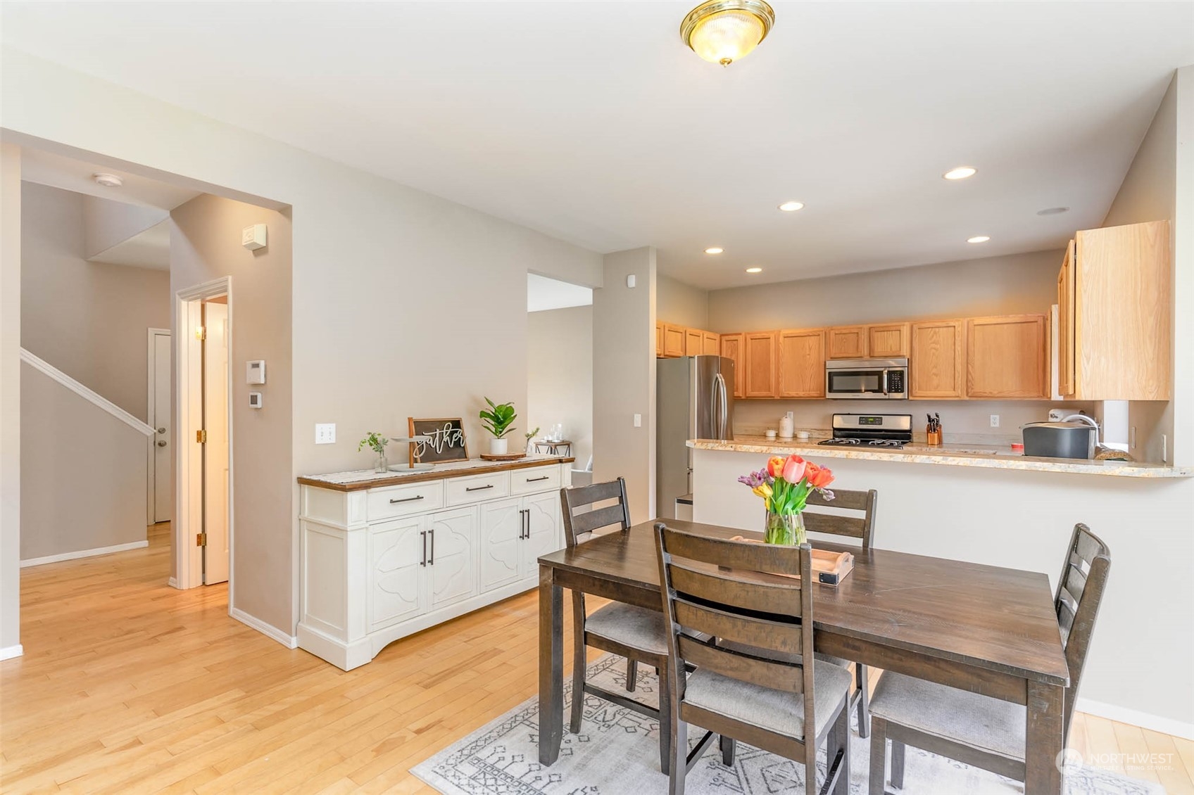 15503 Cedar Grove Road Southeast Issaquah, WA 98027 - Photo 9 of 27 a kitchen with stainless steel appliances kitchen island granite countertop a stove a sink a refrigerator and white cabinets with wooden floor