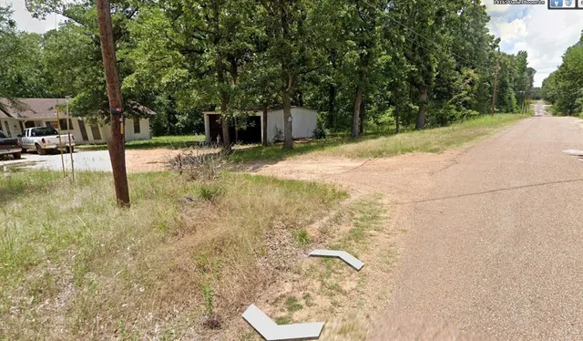a backyard of a house with large trees and outdoor seating