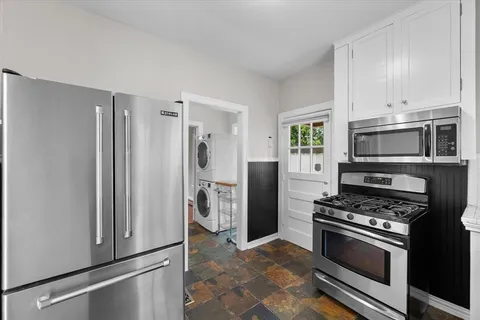 a kitchen with cabinets stainless steel appliances and a window