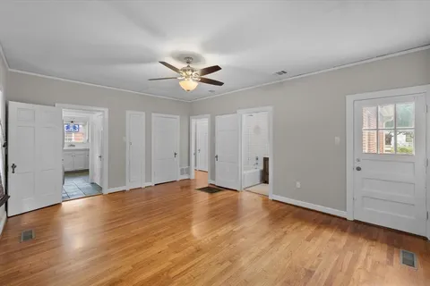 a view of an empty room with window and wooden floor