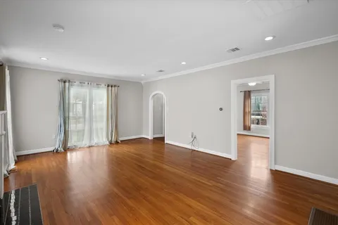 a view of empty room with wooden floor