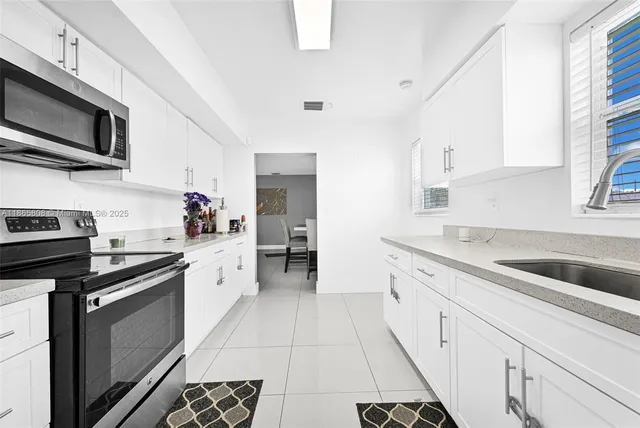 a kitchen with a sink stove and microwave