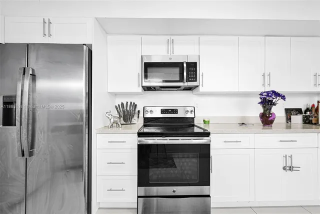 a kitchen with cabinets stainless steel appliances and wooden floor