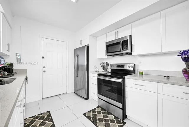 a kitchen with stainless steel appliances granite countertop a stove a refrigerator and a microwave