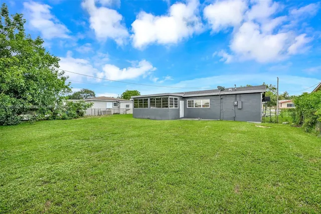 a view of a house with backyard and garden