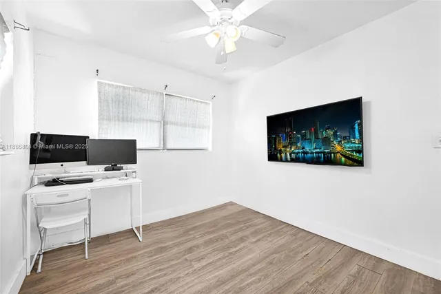 a view of a workspace with furniture and wooden floor