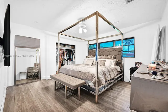 a bedroom with bed and wooden floor