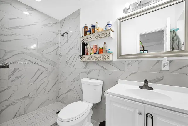 a bathroom with a sink mirror and toilet