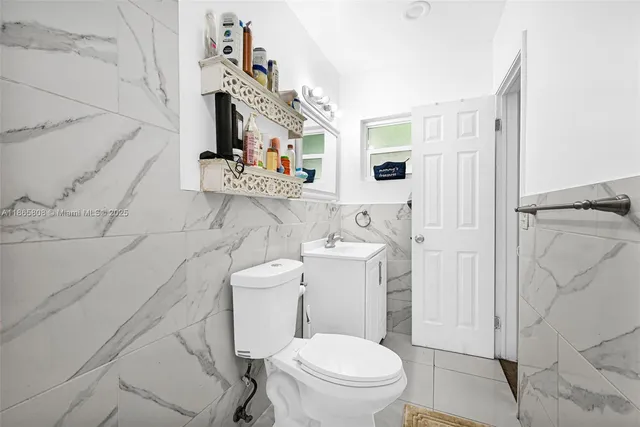 a white toilet sitting next to a bathroom sink