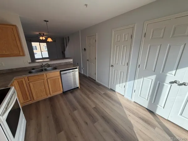 a view of a kitchen with wooden floor and electronic appliances