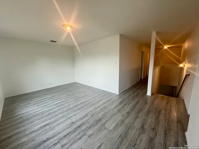 a view of empty room with wooden floor