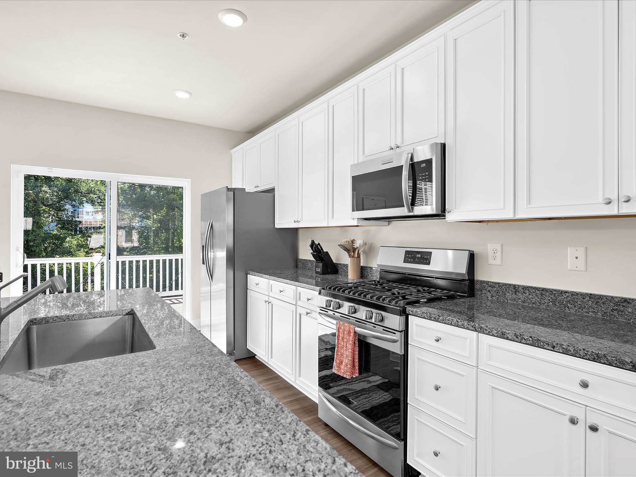 2324 Woodlands Road Baltimore, MD 21244 - Photo 13 of 44 a kitchen with granite countertop a stove a sink and a microwave