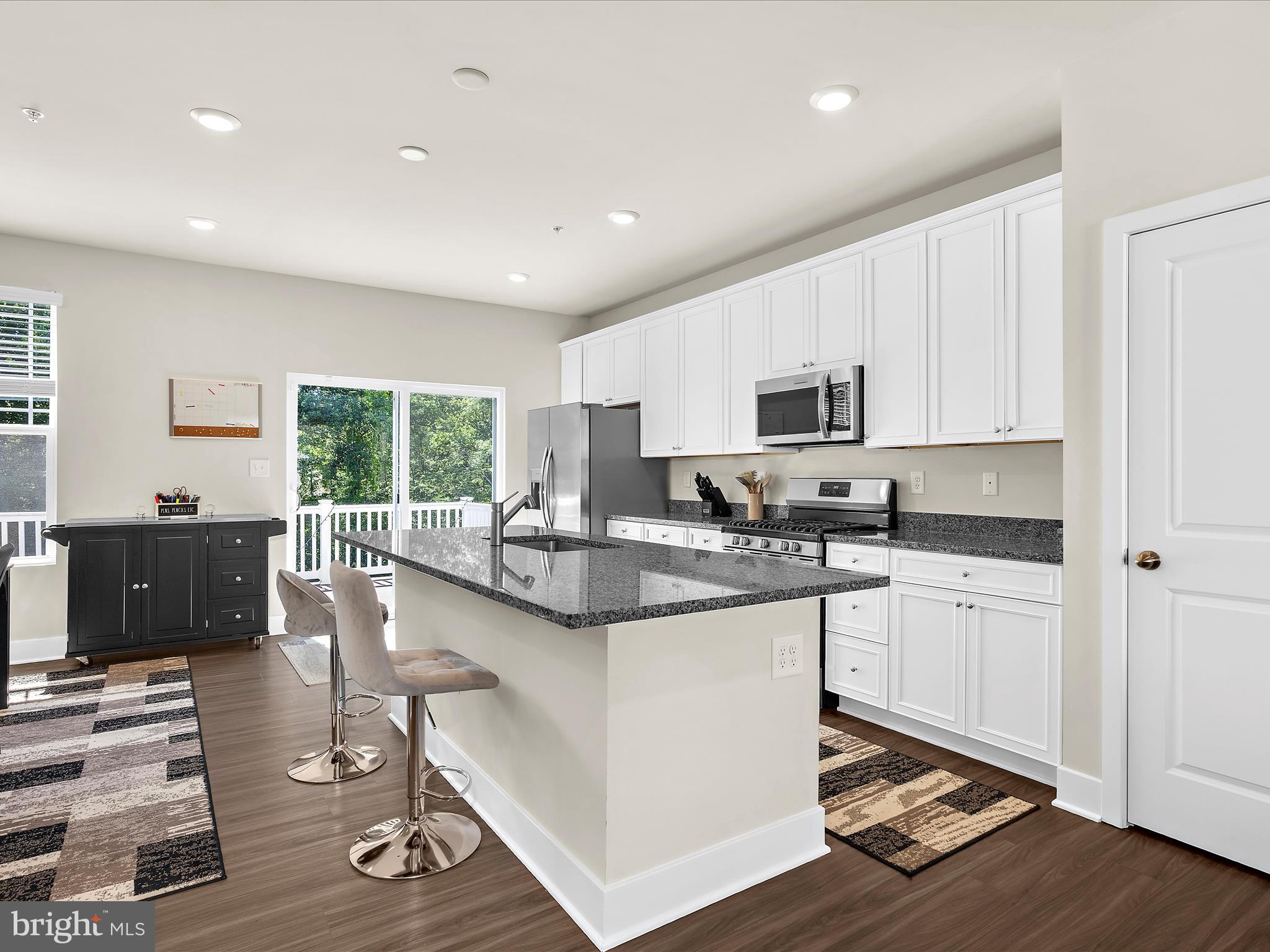 2324 Woodlands Road Baltimore, MD 21244 - Photo 9 of 44 a kitchen with stainless steel appliances granite countertop a stove a sink a refrigerator and white cabinets with wooden floor