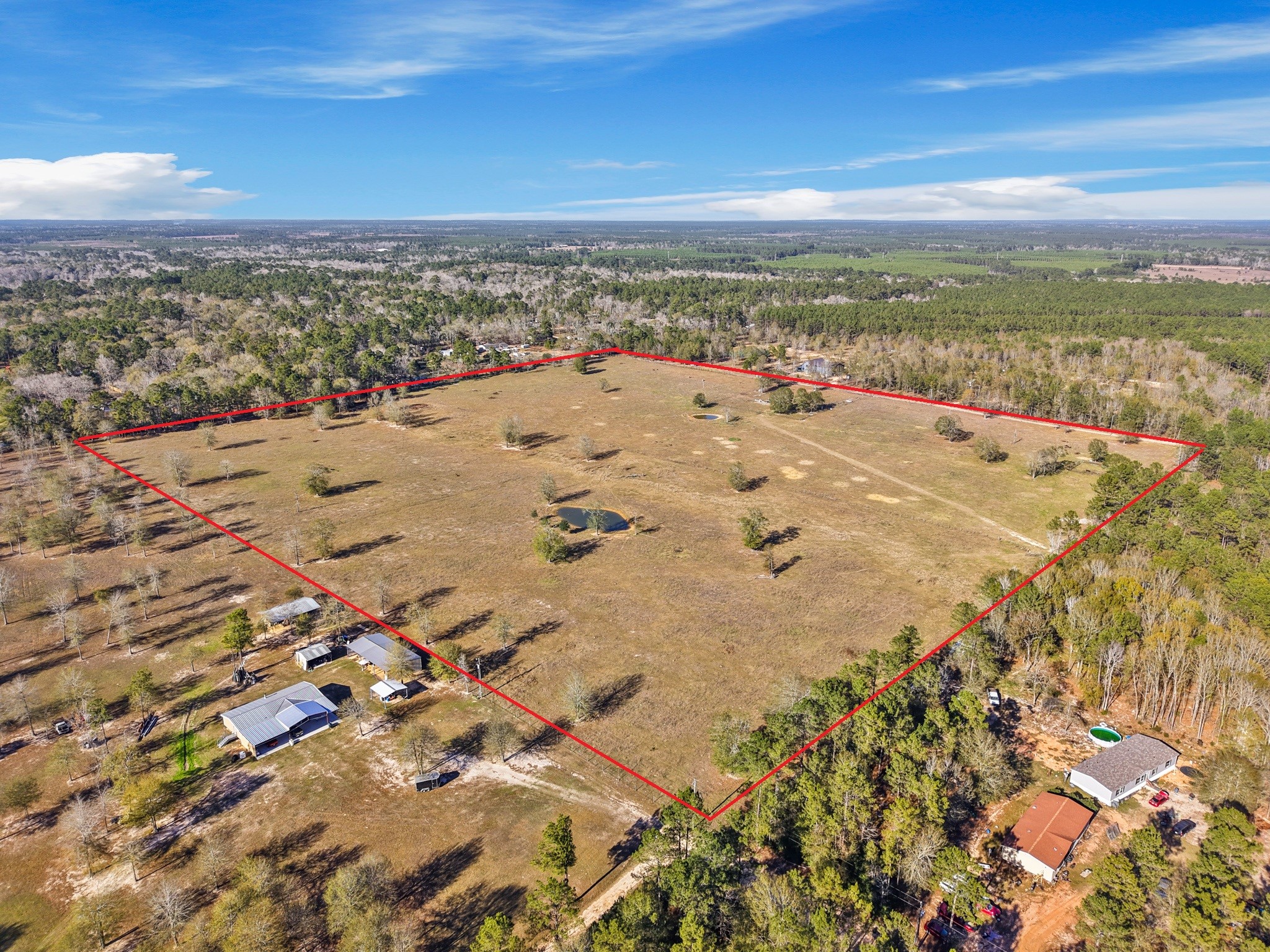 This expansive aerial view highlights a rare 39+ acre property, offering wide-open space, privacy, and endless potential.