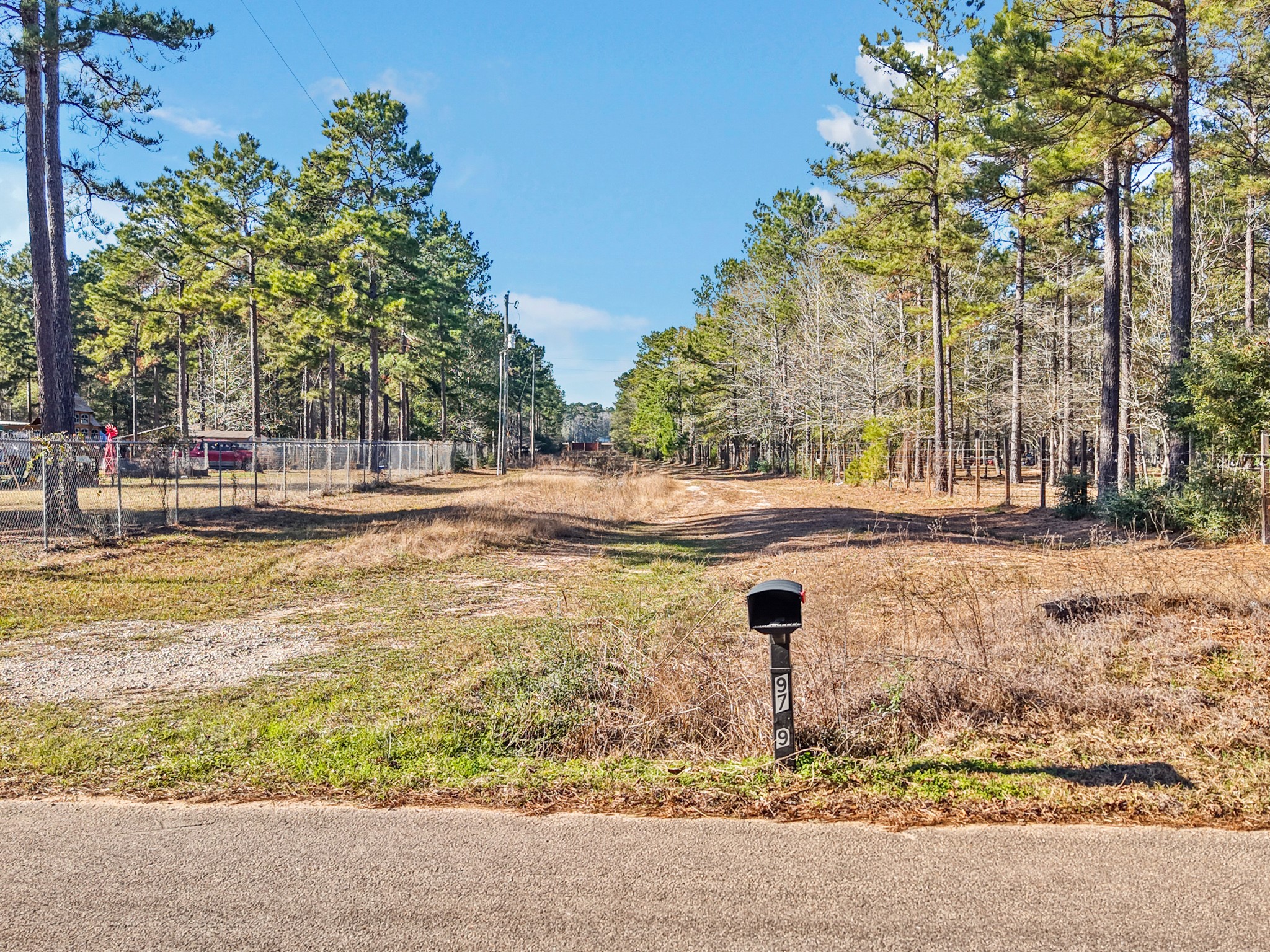 9789 North Walker Road Cleveland, TX 77328 - Photo 3 of 10 This photo highlights the property’s direct road frontage, offering easy and convenient access from the paved roadway.