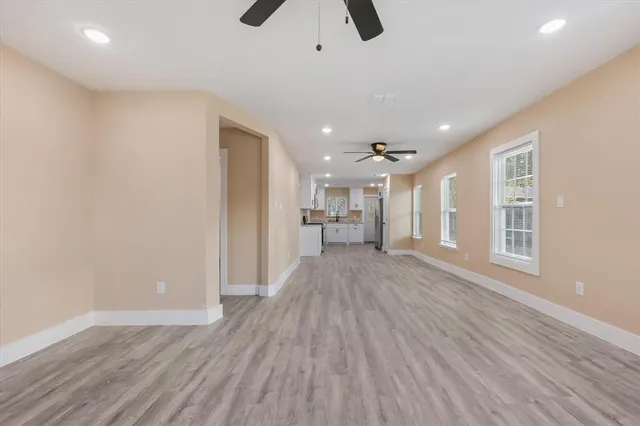 a view of empty room with wooden floor and window