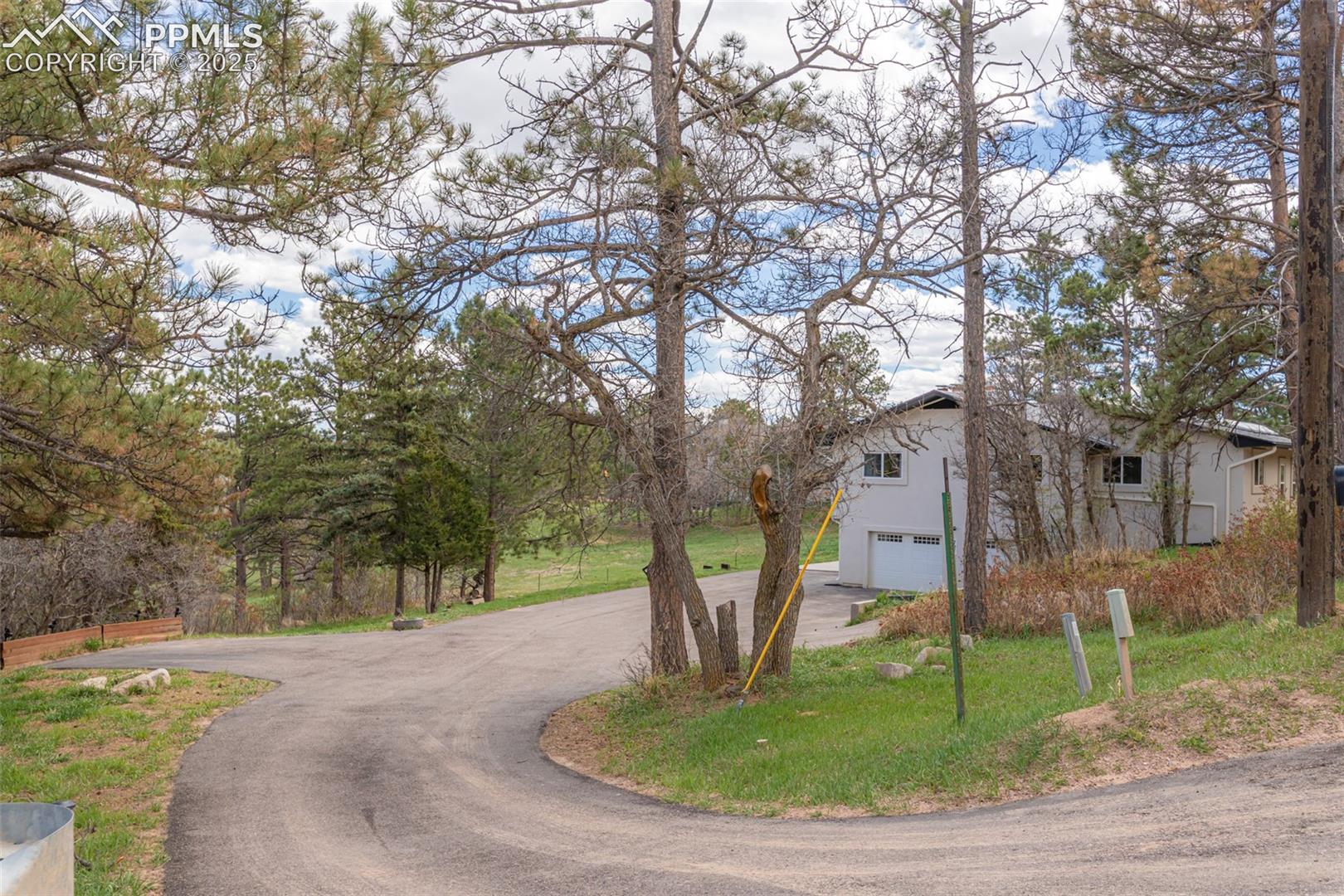 721 Forest View Road Monument, CO 80132 - Photo 2 of 47 long driveway with parking on the left and right up to the front door.