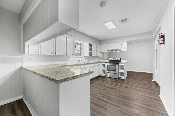 a kitchen with a sink cabinets and wooden floor