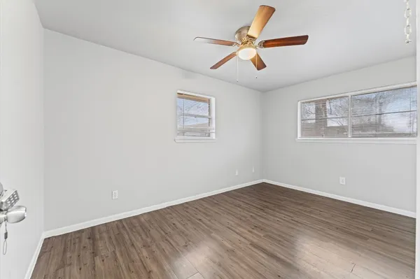 a view of room with wooden floor and ceiling fan