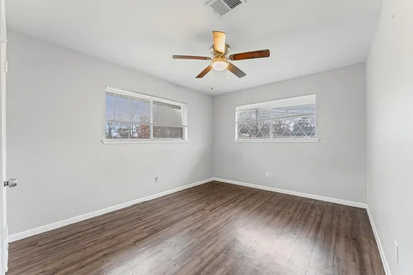 a view of empty room with wooden floor