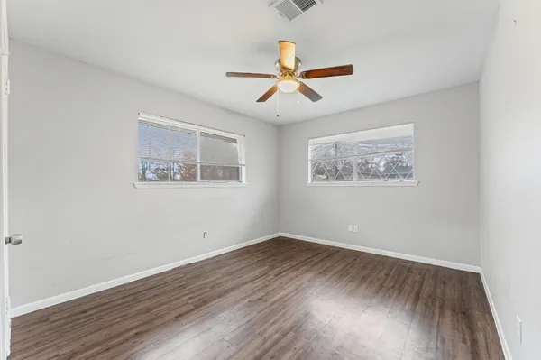 a view of empty room with wooden floor