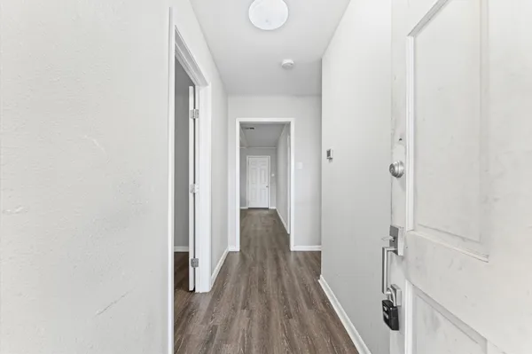 a view of a hallway with wooden floor and staircase