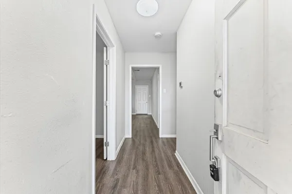 a view of a hallway with wooden floor and staircase