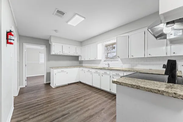 a kitchen with granite countertop white cabinets and white appliances
