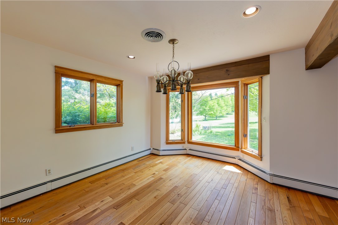 7969 Dines Road Novelty, OH 44072 - Photo 12 of 48 Dining area with bay window with wood-finish trim, hardwood flooring, recessed lighting, and a decorative chandelier