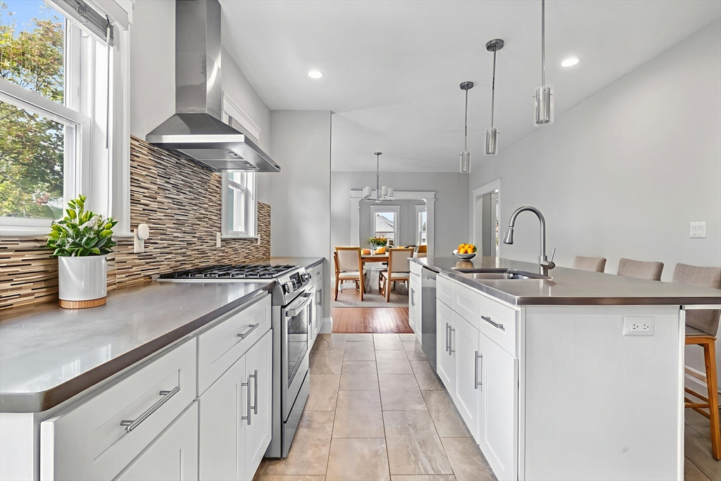 a kitchen with stainless steel appliances a sink stove and cabinets