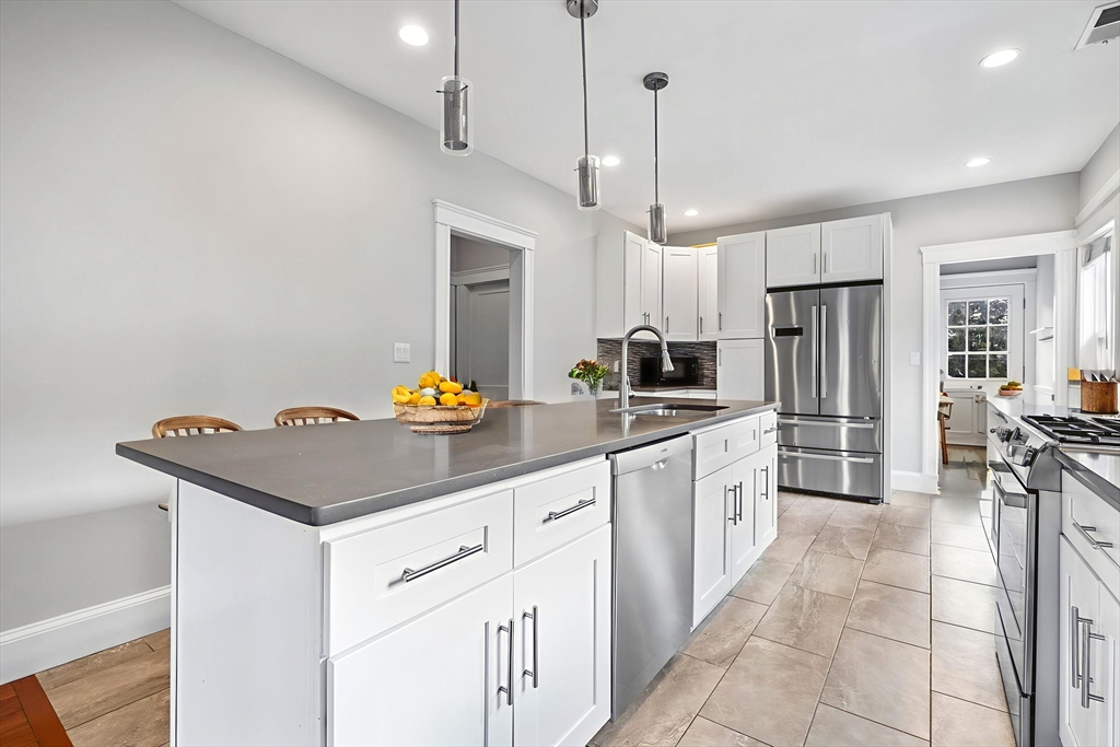 582 High Street, Unit 2 Medford, MA 02155 - Photo 2 of 27 a kitchen with stainless steel appliances a sink a stove a refrigerator and island