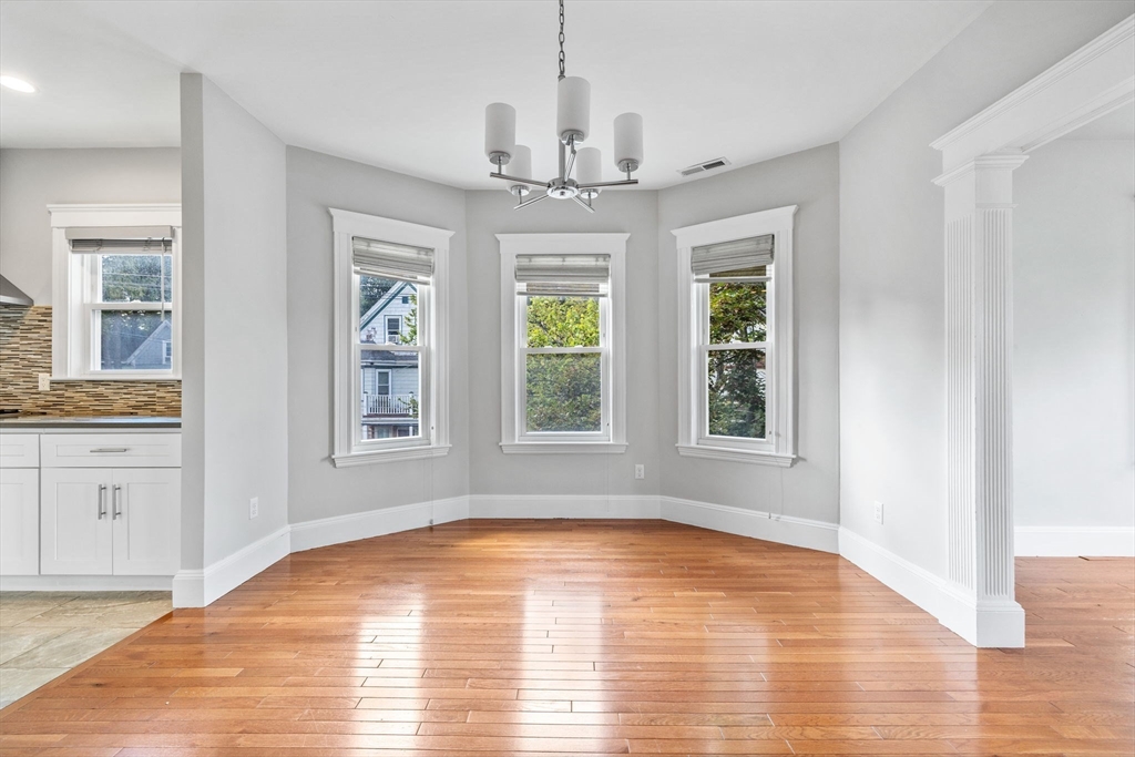 582 High Street, Unit 2 Medford, MA 02155 - Photo 6 of 27 a view of an empty room with a window and wooden floor