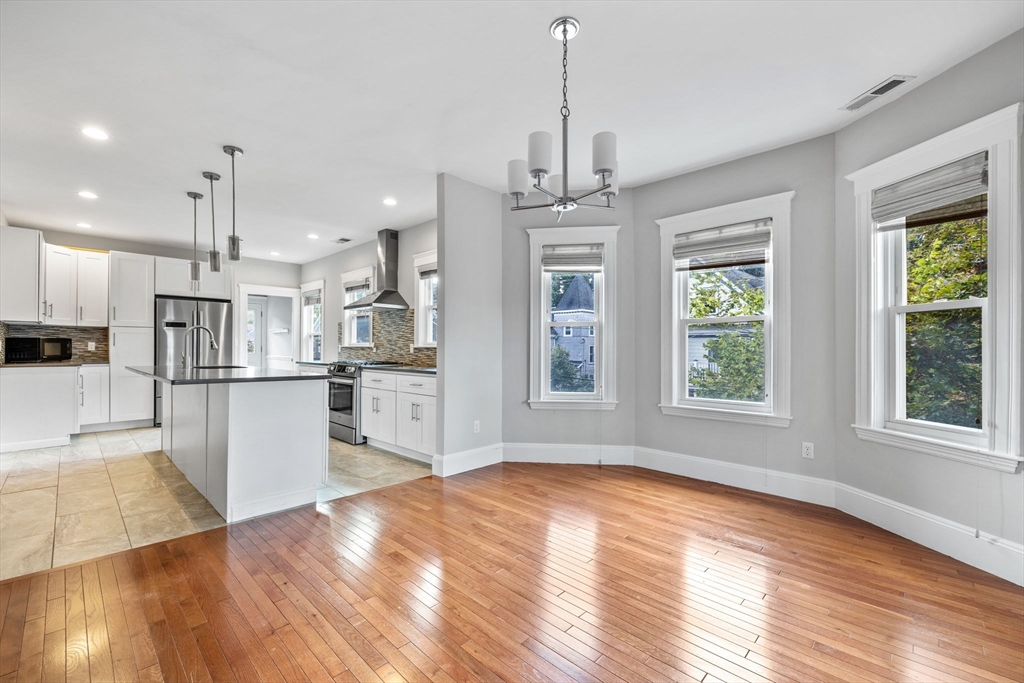 582 High Street, Unit 2 Medford, MA 02155 - Photo 7 of 27 a view of kitchen with refrigerator stove and wooden floor