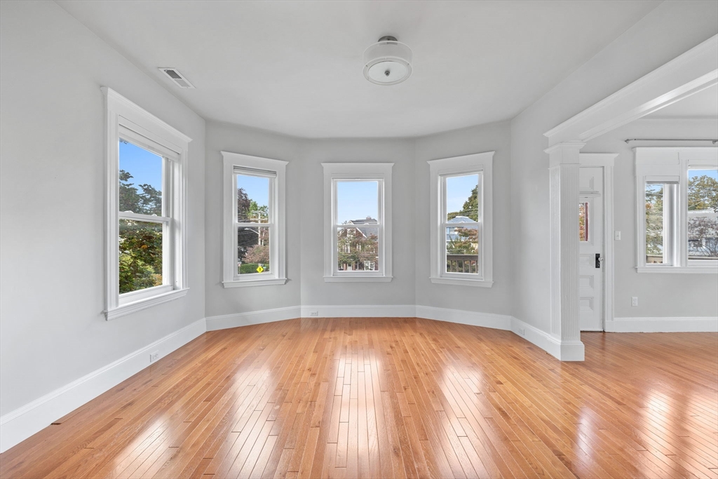 582 High Street, Unit 2 Medford, MA 02155 - Photo 8 of 27 an empty room with wooden floor and windows