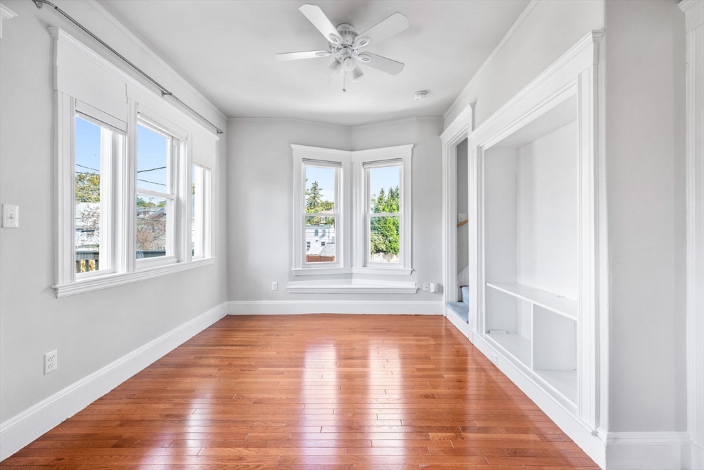 582 High Street, Unit 2 Medford, MA 02155 - Photo 10 of 27 a view of an empty room with a window and wooden floor