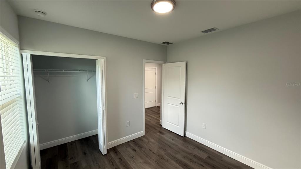 11079 Kimberly Avenue Englewood, FL 34224 - Photo 12 of 14 an empty room with wooden floor and windows